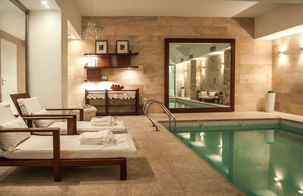 a pool with chaise lounge chairs and a swimming pool at Awwa Suites & Spa in Buenos Aires