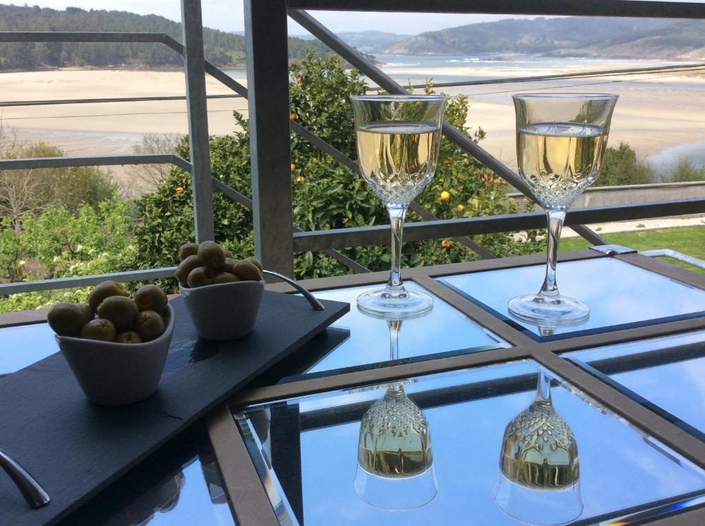 dos copas de vino en una mesa con vistas en Casa Mar de Fondo, en A Telleira