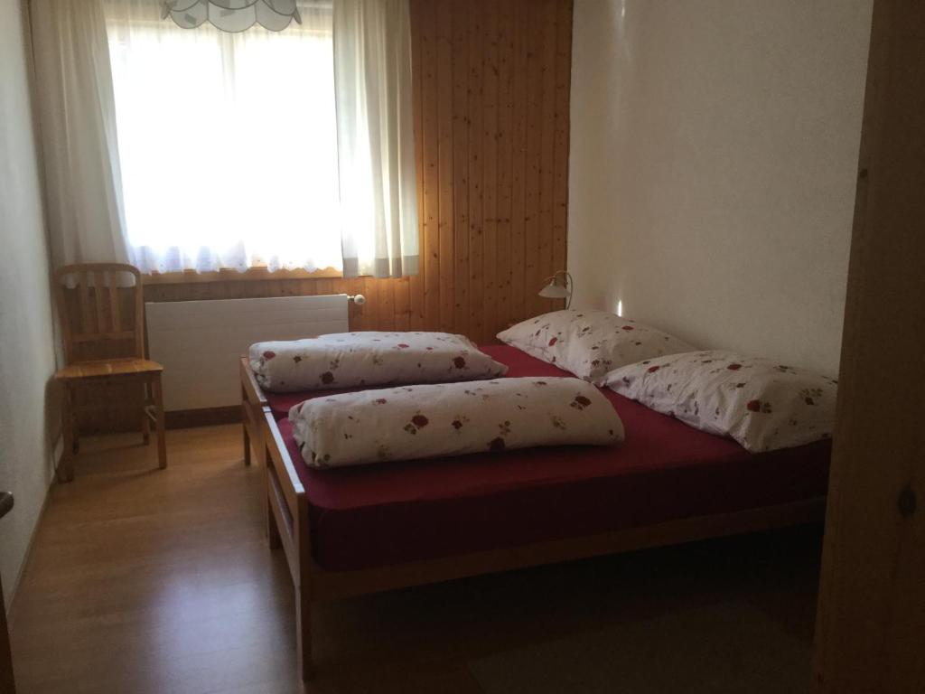 two twin beds in a room with a window at Haus Wiedersehn in Blitzingen