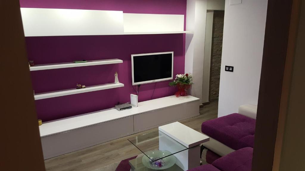 ein Wohnzimmer mit lila Wänden und einem TV in der Unterkunft Moderno apartamento en el parque de cabecera in Valencia