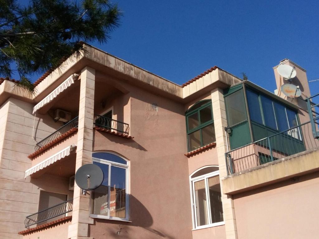 a building with a balcony and a blue sky at Apartman Ćeran in Herceg-Novi