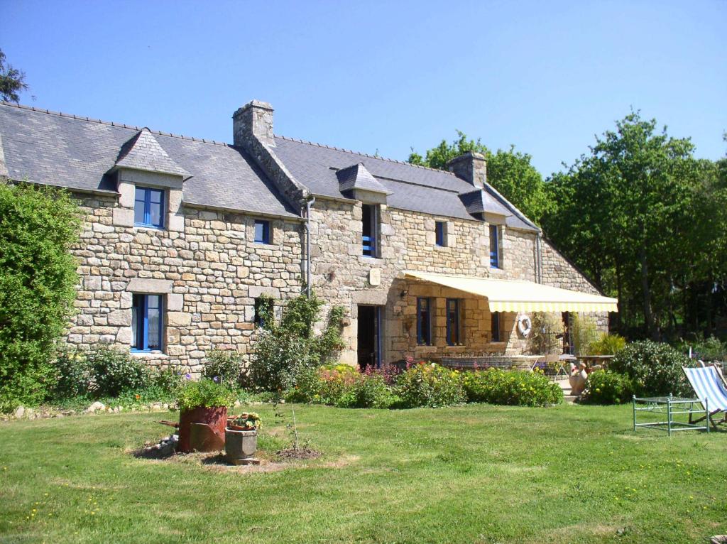 una gran casa de piedra con césped delante en Auberge De Bel Air, en Brélès