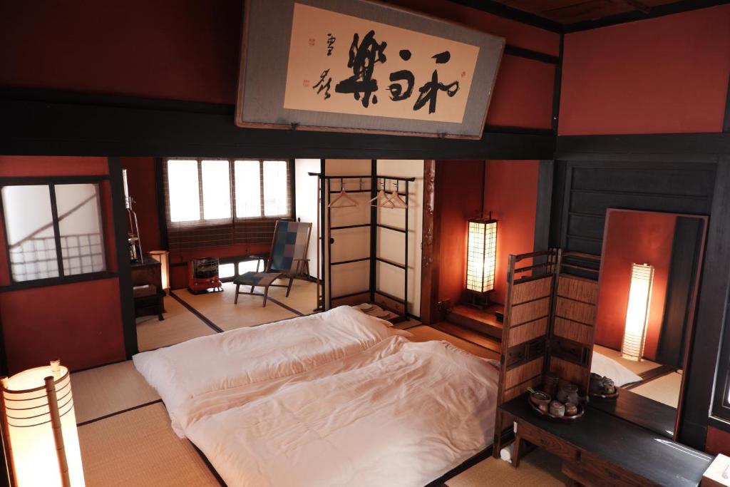 una camera con un letto in una stanza con un cartello di 一棟貸ゲストハウス 傾㐂屋 Kabukiya a Hiroshima