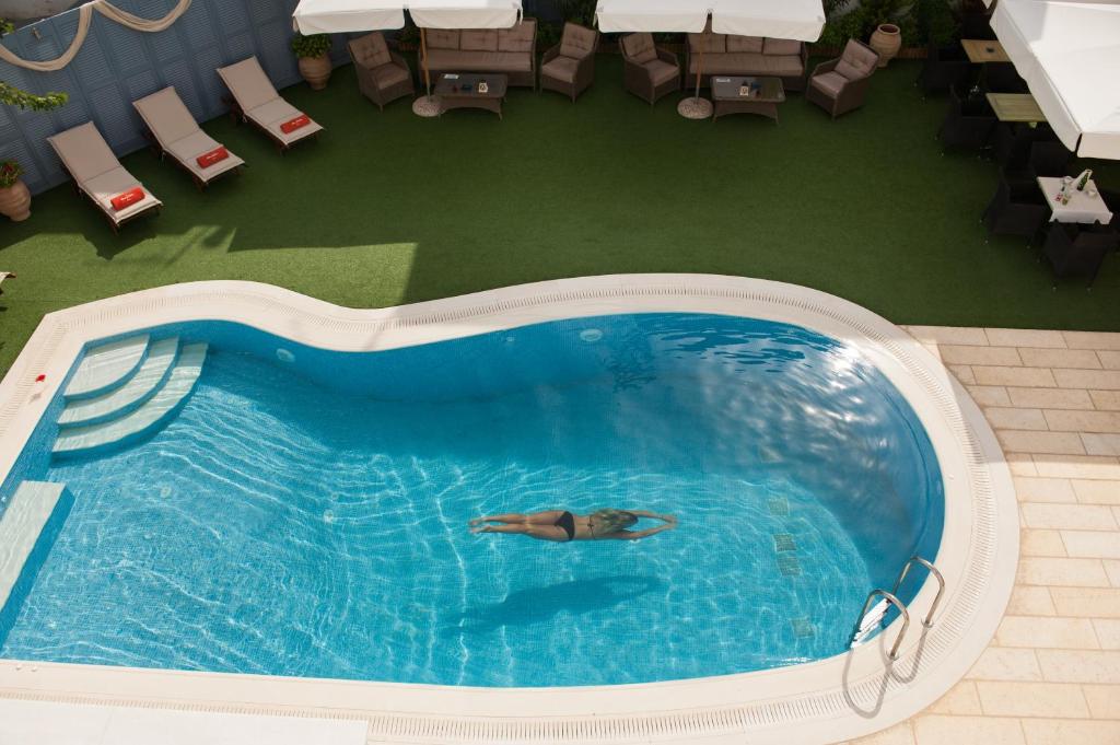 a person swimming in a swimming pool at Anna Platanou Hotel in Parikia