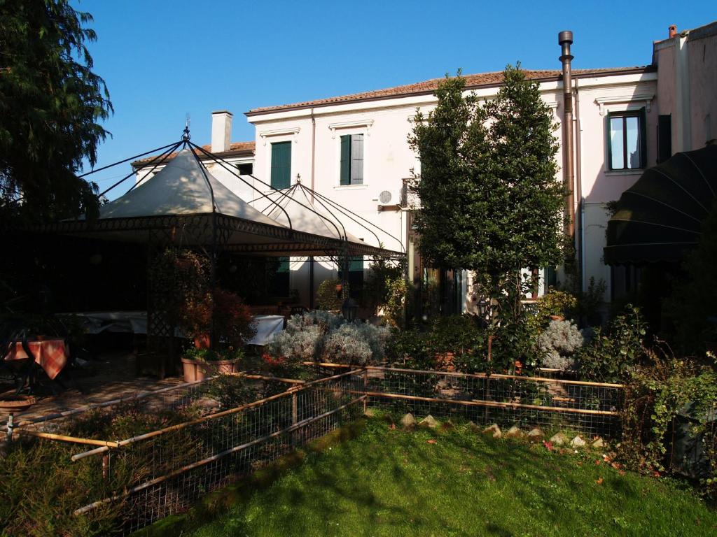 un jardin en face d'une maison blanche dans l'établissement Agriturismo Le Clementine, à Badia Polesine