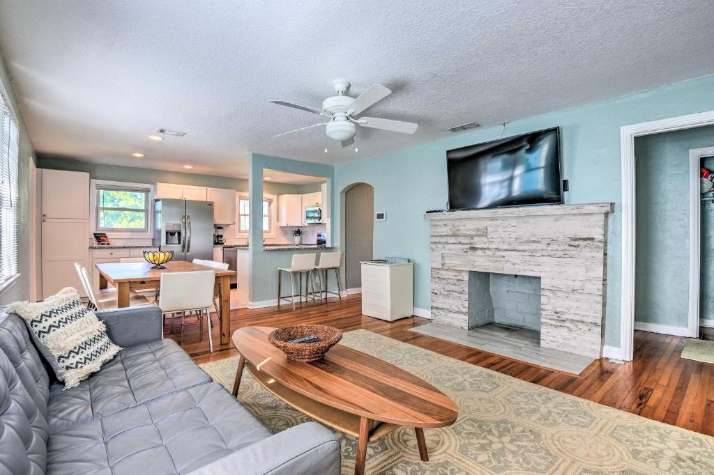 a living room with a couch and a tv on a fireplace at Modern Seaview House - 200 Yards to Daytona Beach! in Daytona Beach