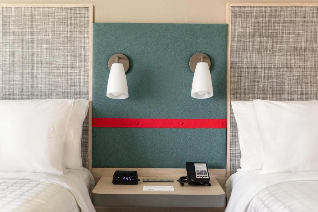 a hotel room with two beds and a phone on a table at avid hotel Nashville - Lebanon an IHG Hotel in Lebanon