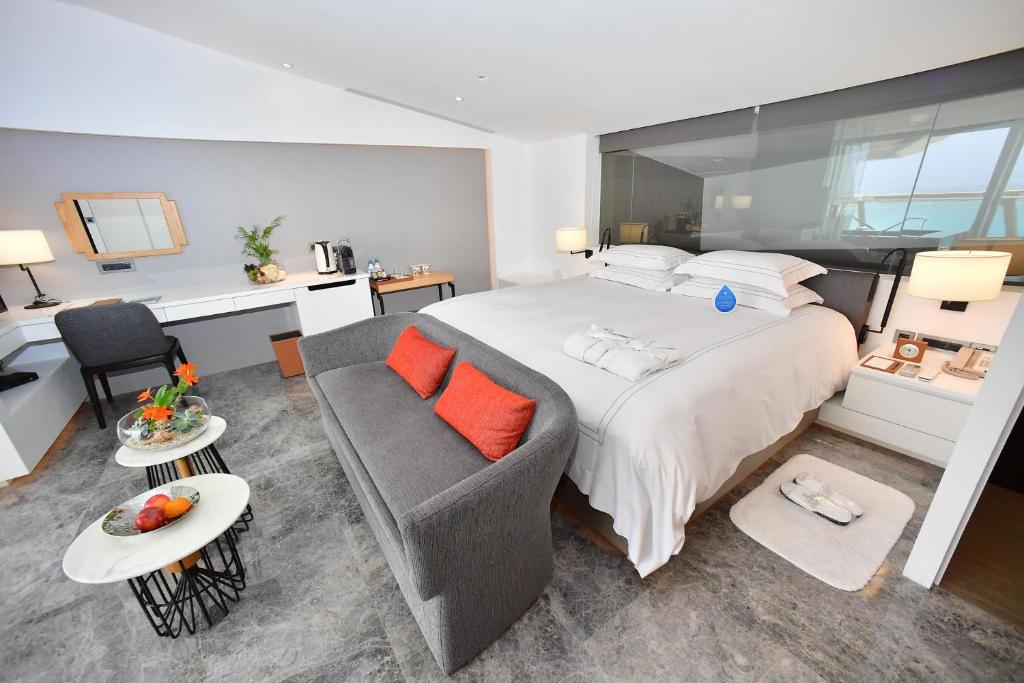 a bedroom with a large bed and a couch at Volando Kenting in Hengchun