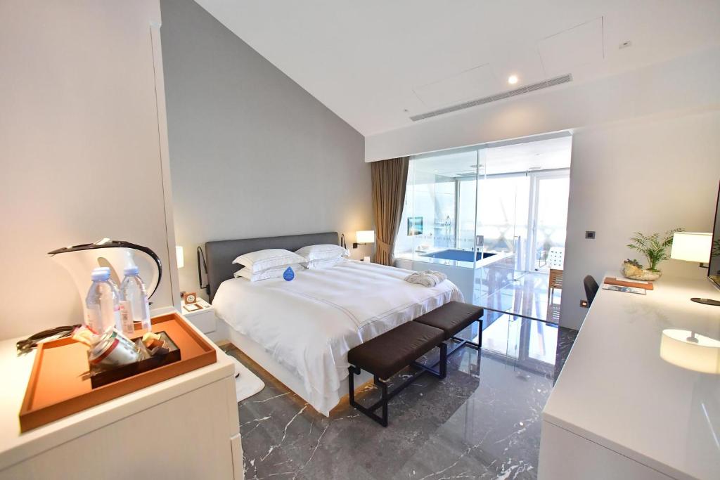 a bedroom with a bed and a desk with a lamp at Volando Kenting in Hengchun