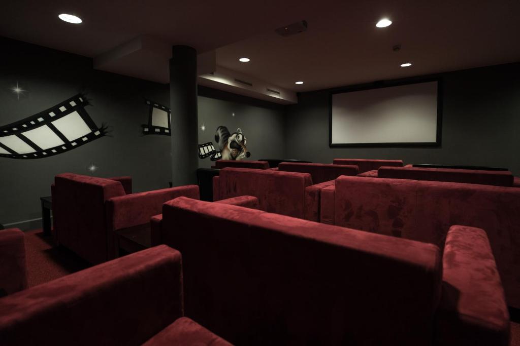 a cinema room with red chairs and a screen at Schlosshotel Fiss in Fiss