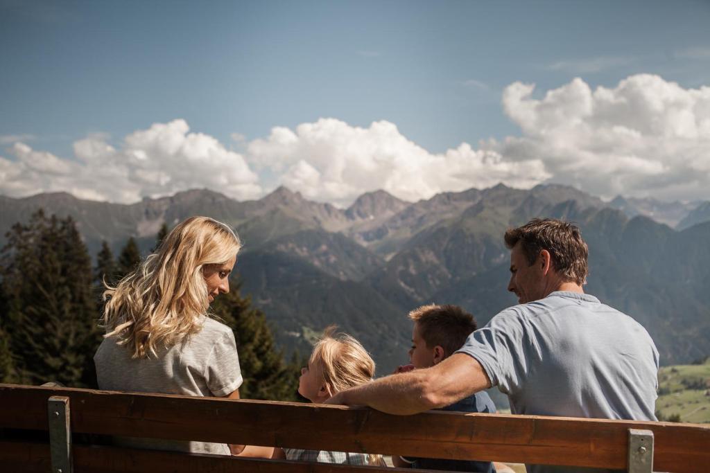 a group of people sitting on a bench in the mountains at Schlosshotel Fiss in Fiss