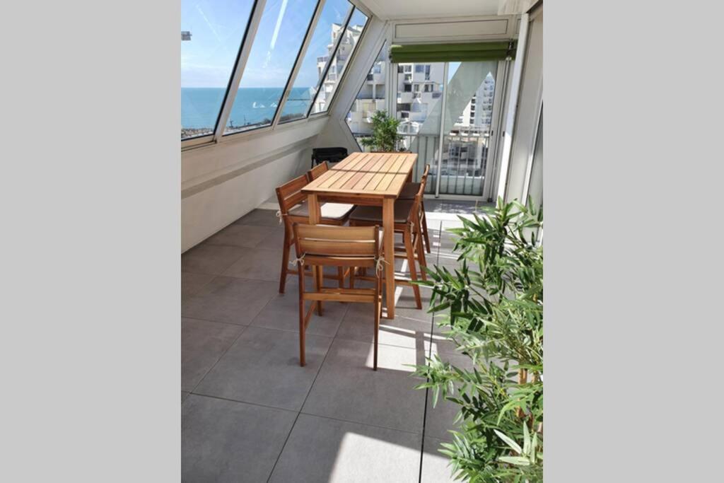 a balcony with a table and chairs and the ocean at LE MARADIVA - P3 vue imprenable mer-garage - plages in La Grande-Motte