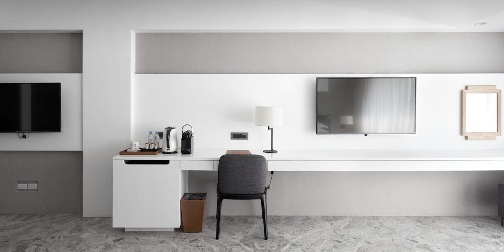 a white desk with a chair in a room at Volando Kenting in Hengchun