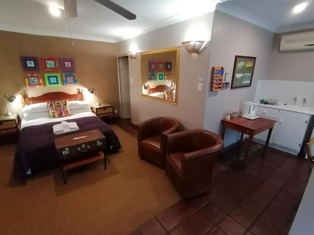 a hotel room with a bed and a chair at Dias Guest House in Bloemfontein