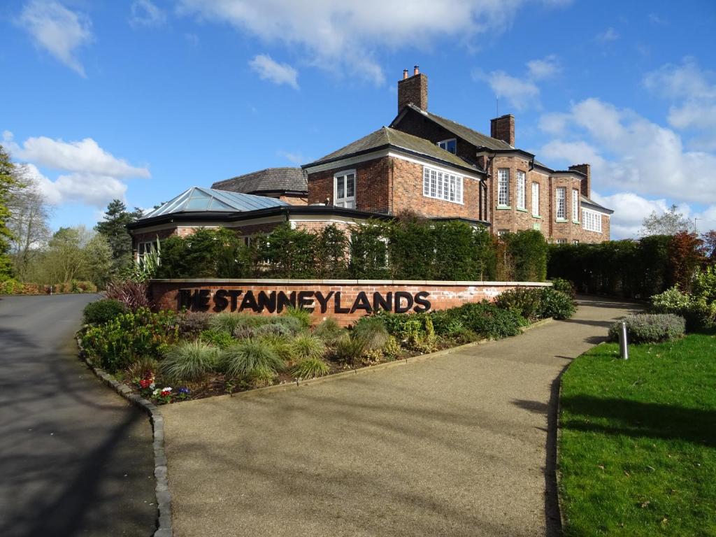 una casa con un cartel delante de ella en The Stanneylands en Wilmslow