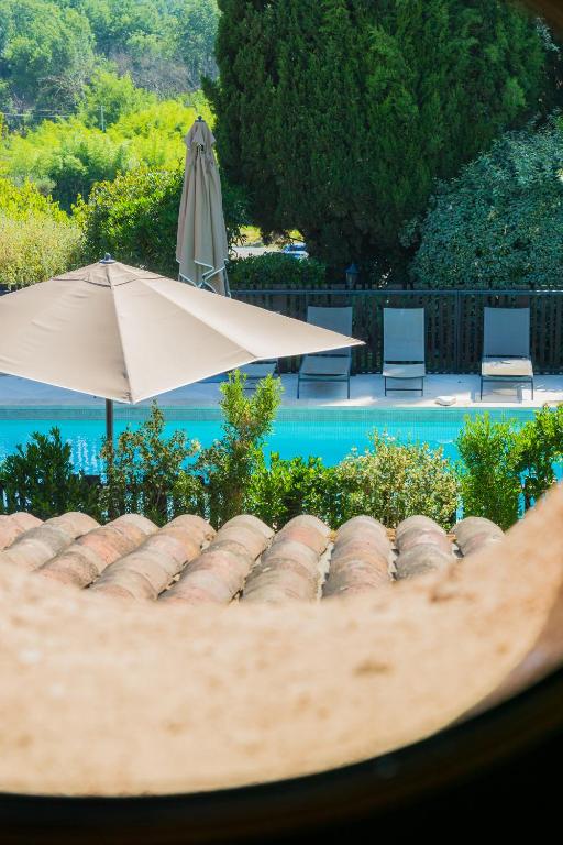 un toit d'une maison avec un parasol et une piscine dans l'établissement Chateau des Bertrands, au Cannet-des-Maures