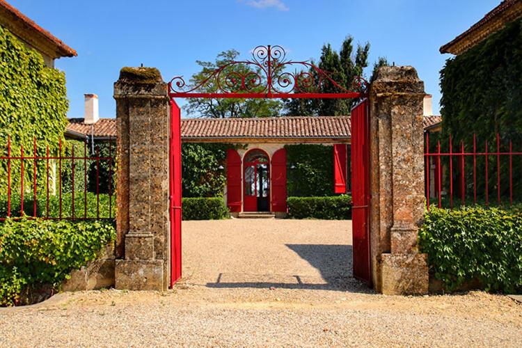 a red gate in front of a house at Château Sigalas Rabaud in Bommes
