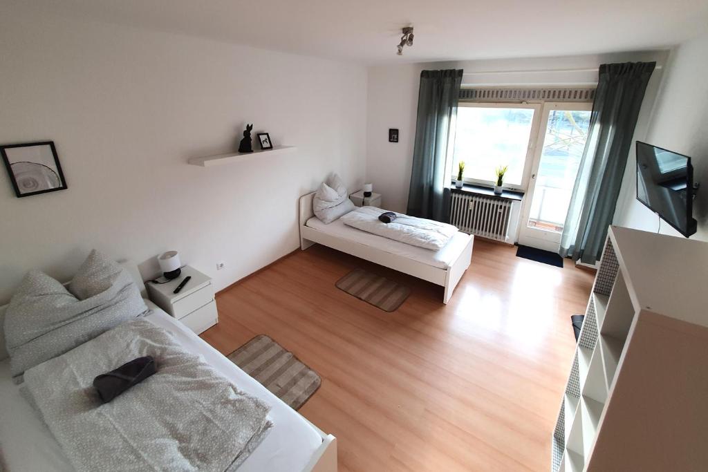 a white living room with a bed and a television at Work & Stay im Herzen von Celle in Celle