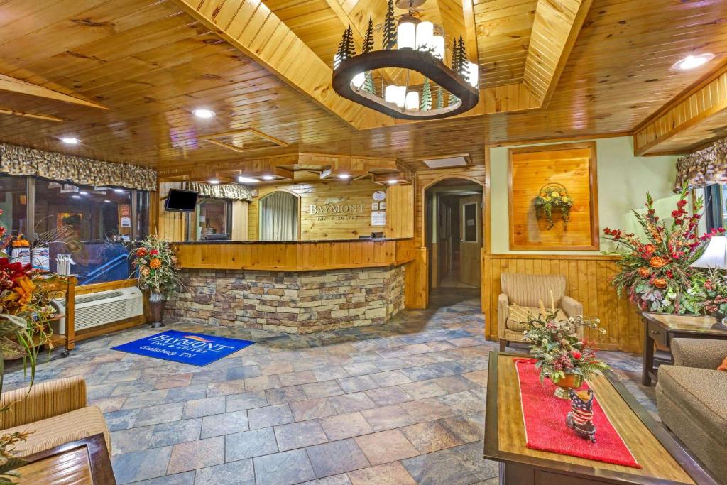 a lobby with a stone fireplace in a building at Baymont by Wyndham Gatlinburg On The River in Gatlinburg