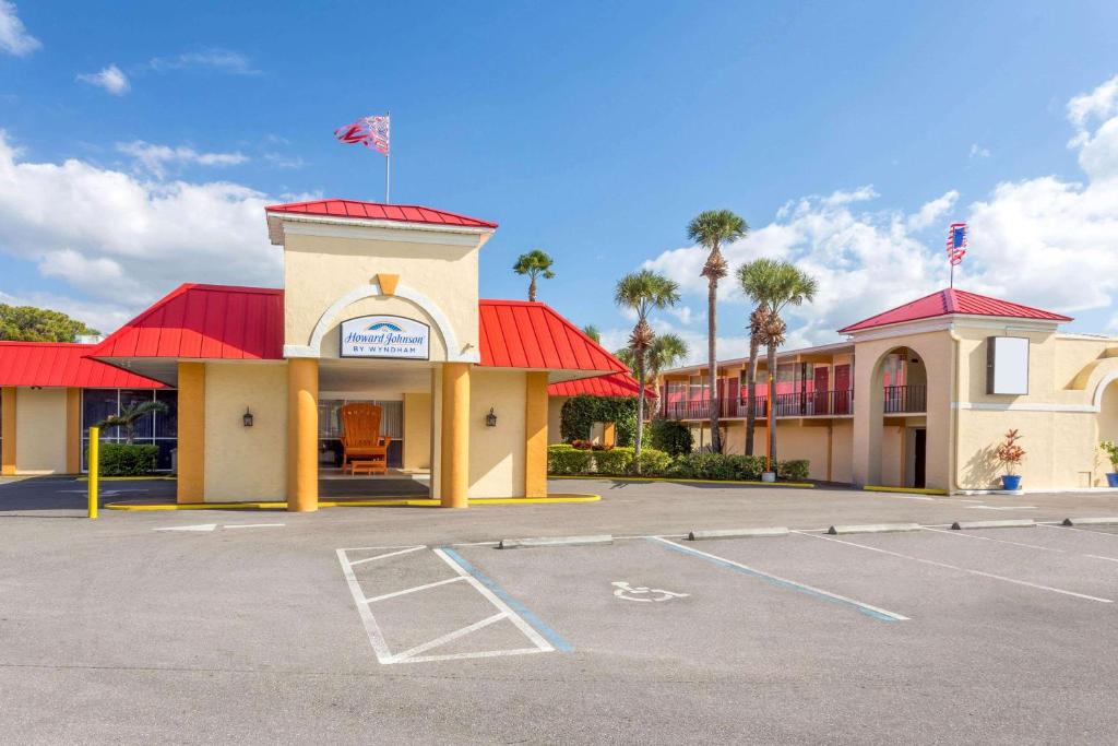a building with a red roof and a parking lot at Howard Johnson by Wyndham Lakeland in Lakeland