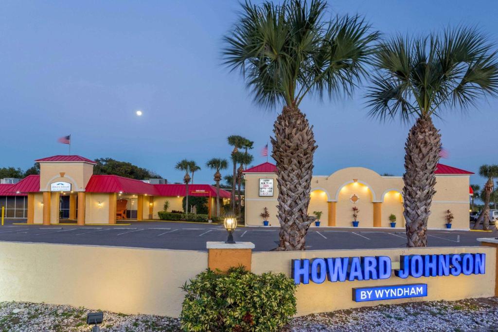 a hotel with palm trees in front of a building at Howard Johnson by Wyndham Lakeland in Lakeland