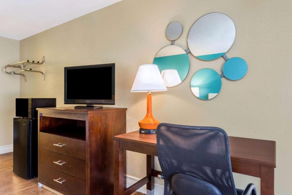 a room with a desk with a tv and a chair at Howard Johnson by Wyndham Lakeland in Lakeland