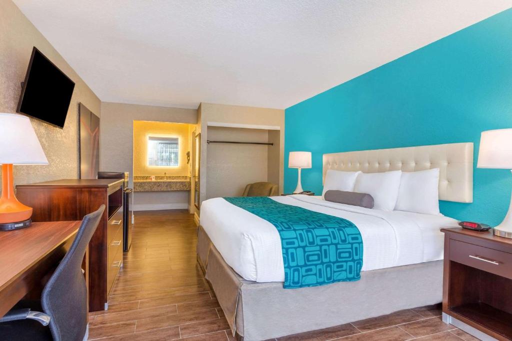 a hotel room with a large bed and a desk at Howard Johnson by Wyndham Lakeland in Lakeland