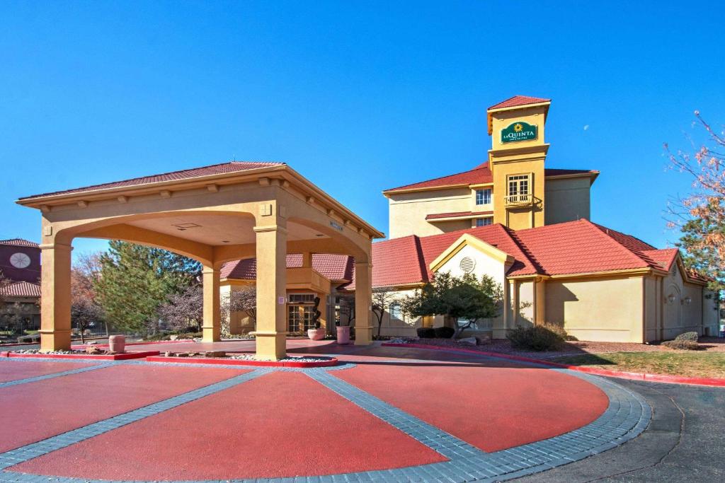 un edificio con una torre de reloj con entrada roja en La Quinta by Wyndham Albuquerque West, en Albuquerque