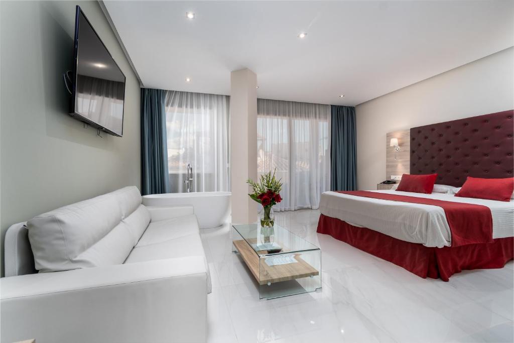 a living room with a large bed and a couch at Los Arcos in Nerja