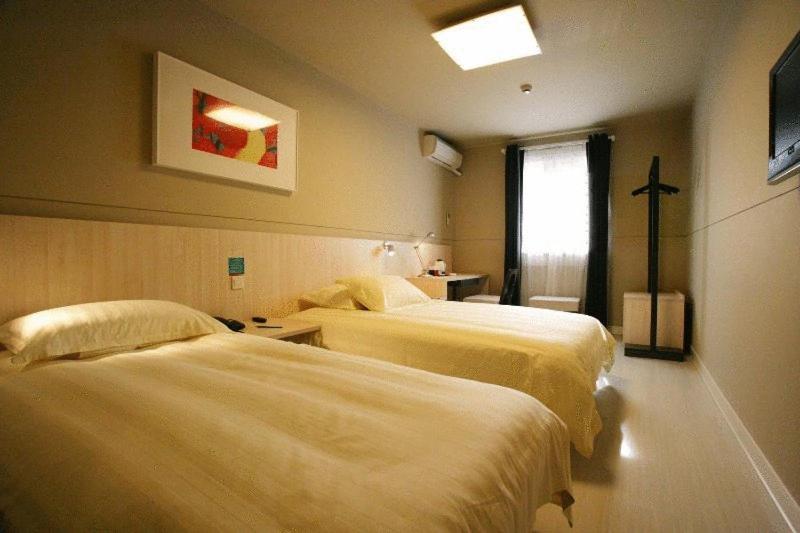 a hotel room with two beds and a window at Jinjiang Inn - Suzhou Wuzhong Baodai West Road in Suzhou