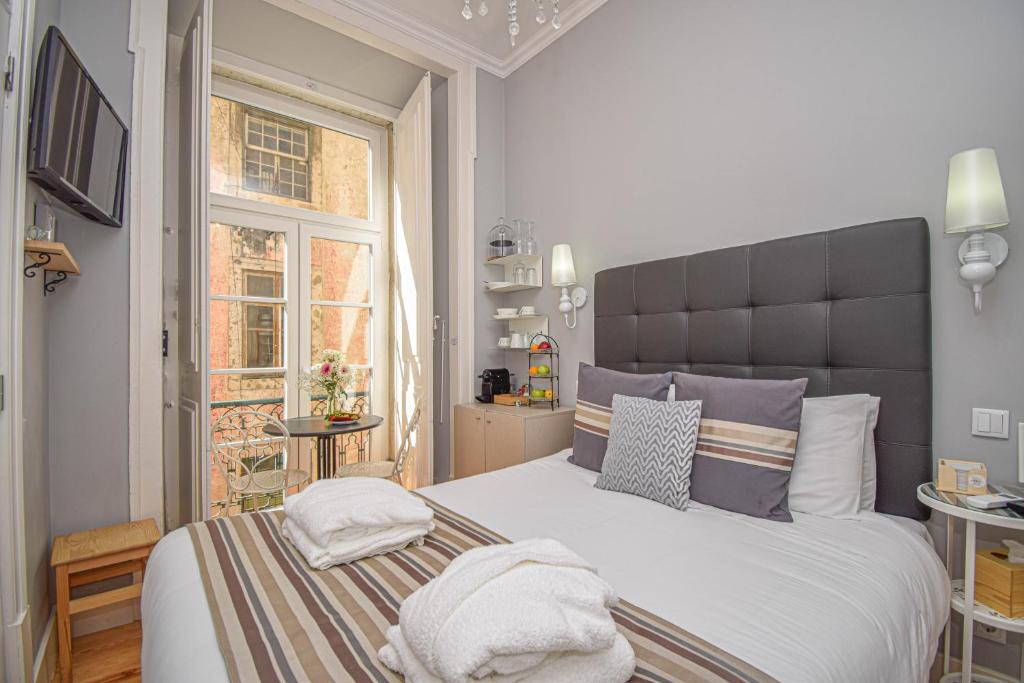 a bedroom with a large bed and a window at B in B Lisbon Downtown Suites in Lisbon