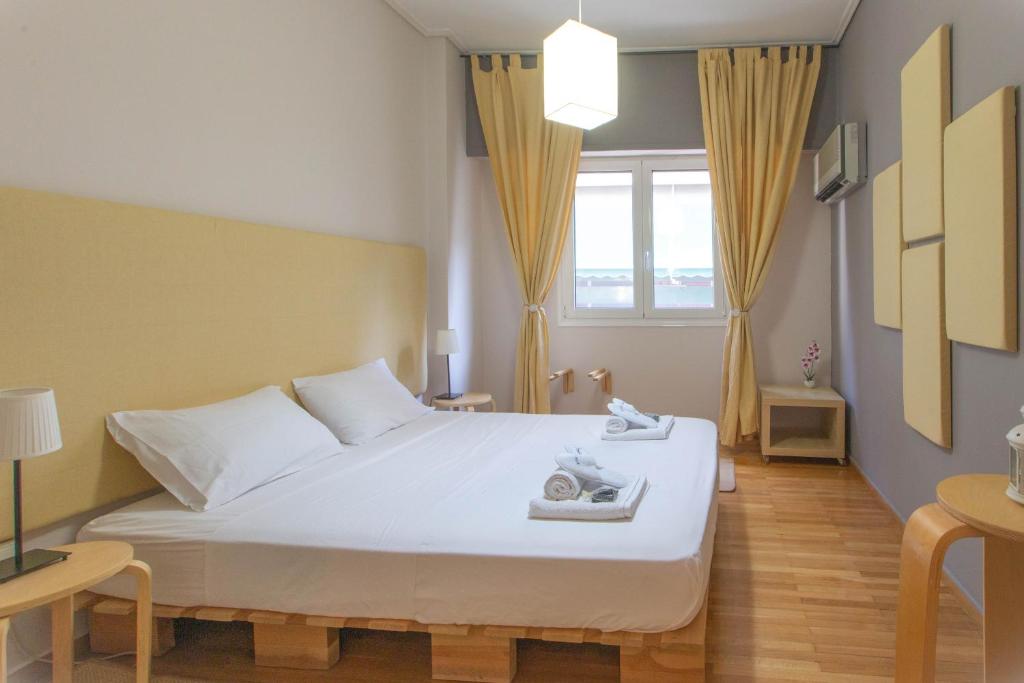 una camera da letto con un grande letto bianco e una finestra di Inspired Townhouse • Bright, Chic & Cozy ad Atene