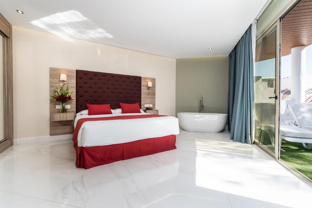 a bedroom with a large bed and a bath tub at Los Arcos in Nerja