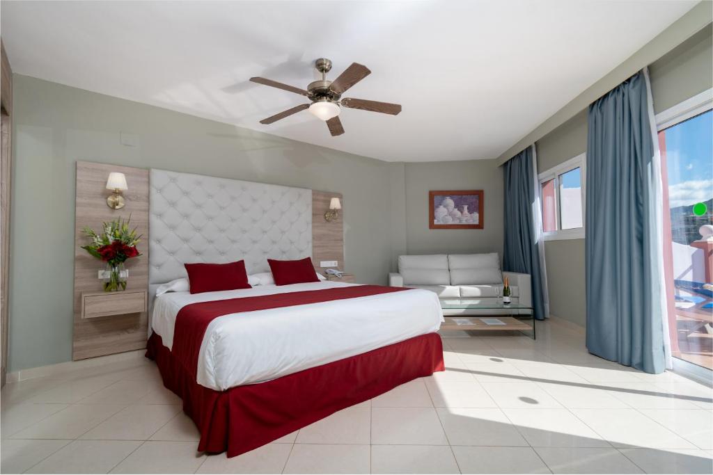 a bedroom with a large bed and a ceiling fan at Los Arcos in Nerja