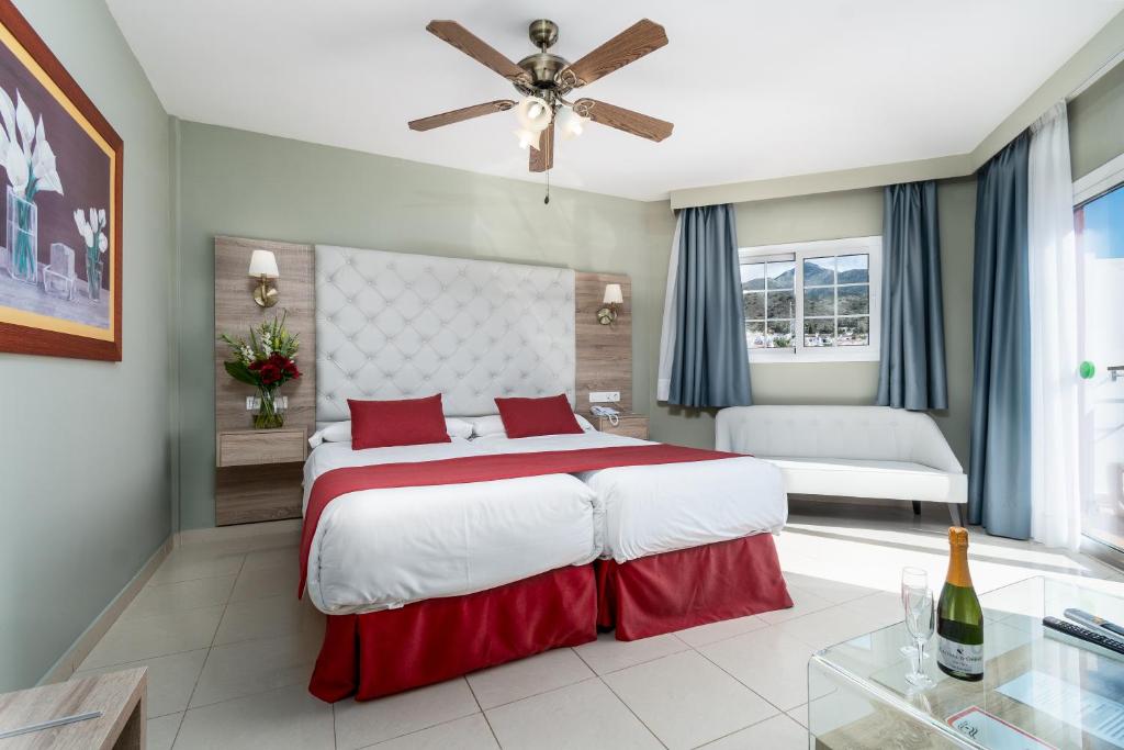 a bedroom with a large bed and a ceiling fan at Los Arcos in Nerja