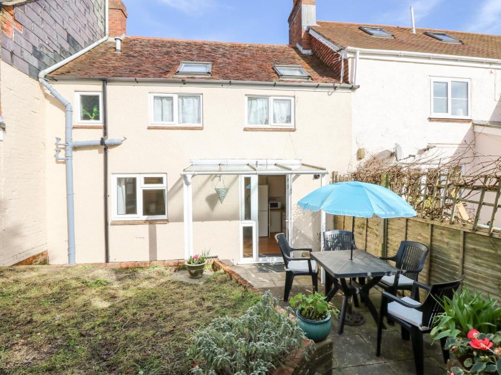 a patio with a table and chairs and an umbrella at Bugle Cottage in Newport