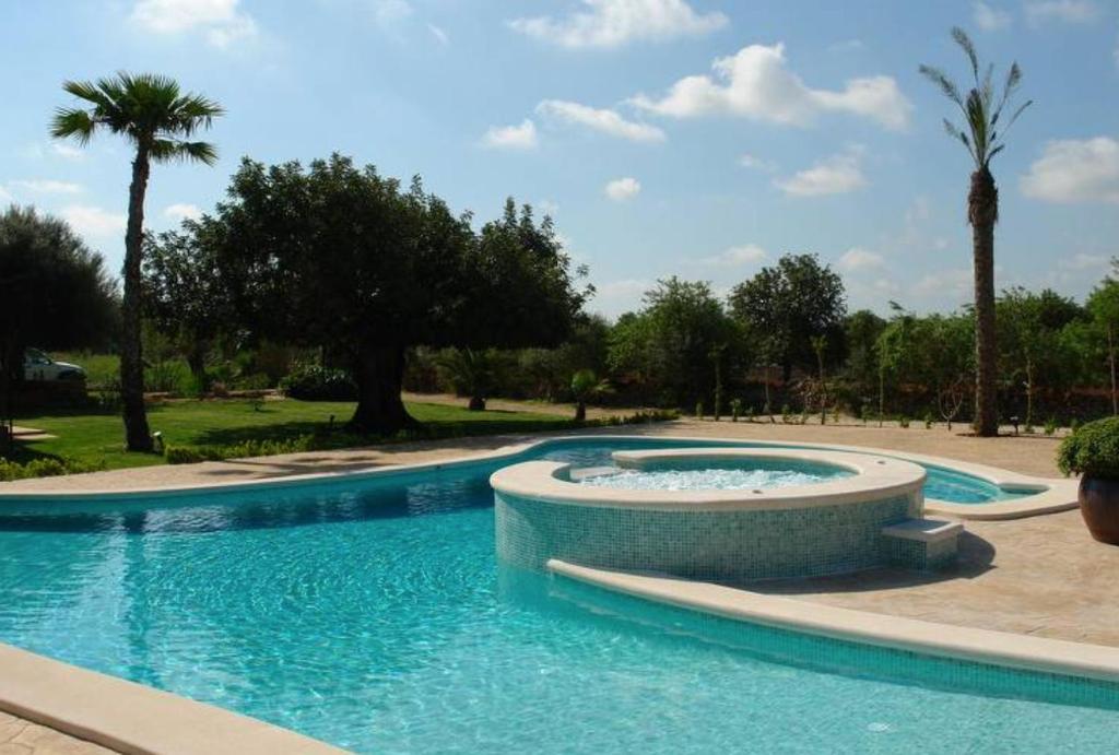 - une piscine dans un complexe avec des palmiers dans l'établissement Mirabo ramonet, à Caʼs Concos