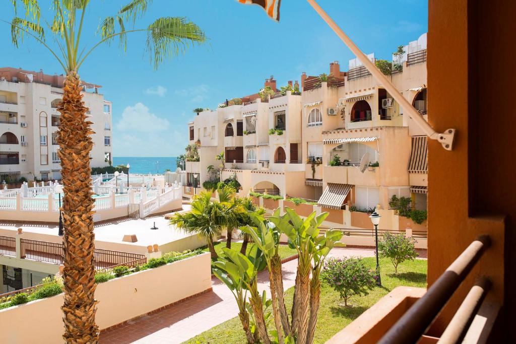 a view from the balcony of a hotel with palm trees at Jardín de Mariote Apartment in Almuñécar