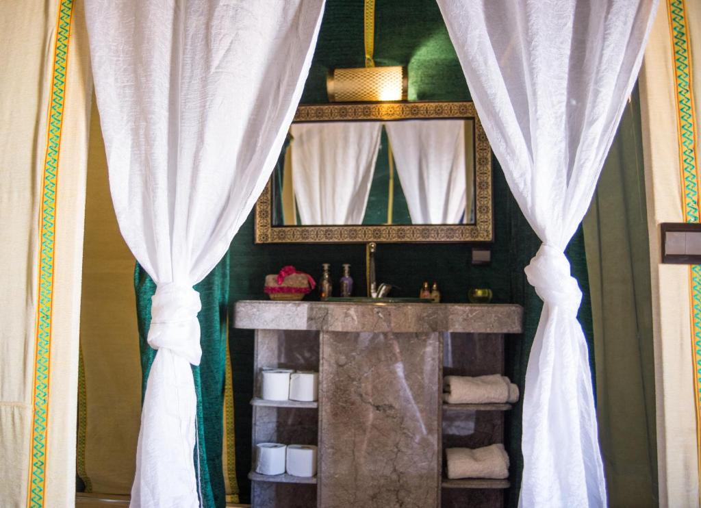 a bathroom with a sink and a mirror at Sahara Luxury Desert Camp in Merzouga