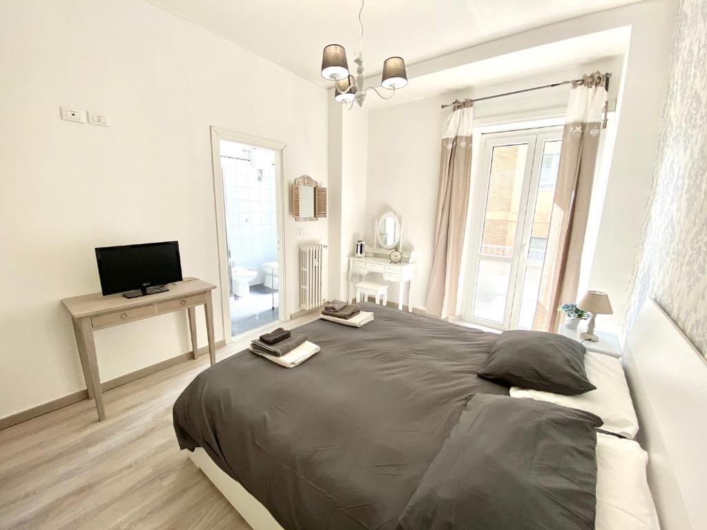 1 dormitorio con 1 cama grande y TV en A Quattro Passi Da, en Roma