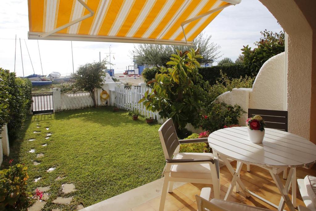 a patio with a table and chairs and a yard at AT034 Platja Creixell in Creixell
