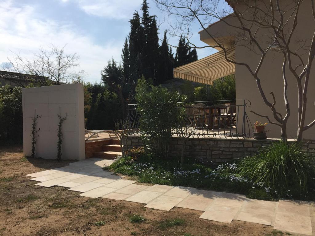 a house with a fence and a patio at Villa Caramel in Saint-Quentin-la-Poterie