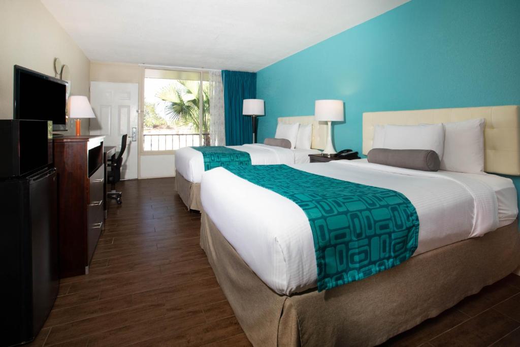 a hotel room with two beds and a television at Howard Johnson by Wyndham Lakeland in Lakeland