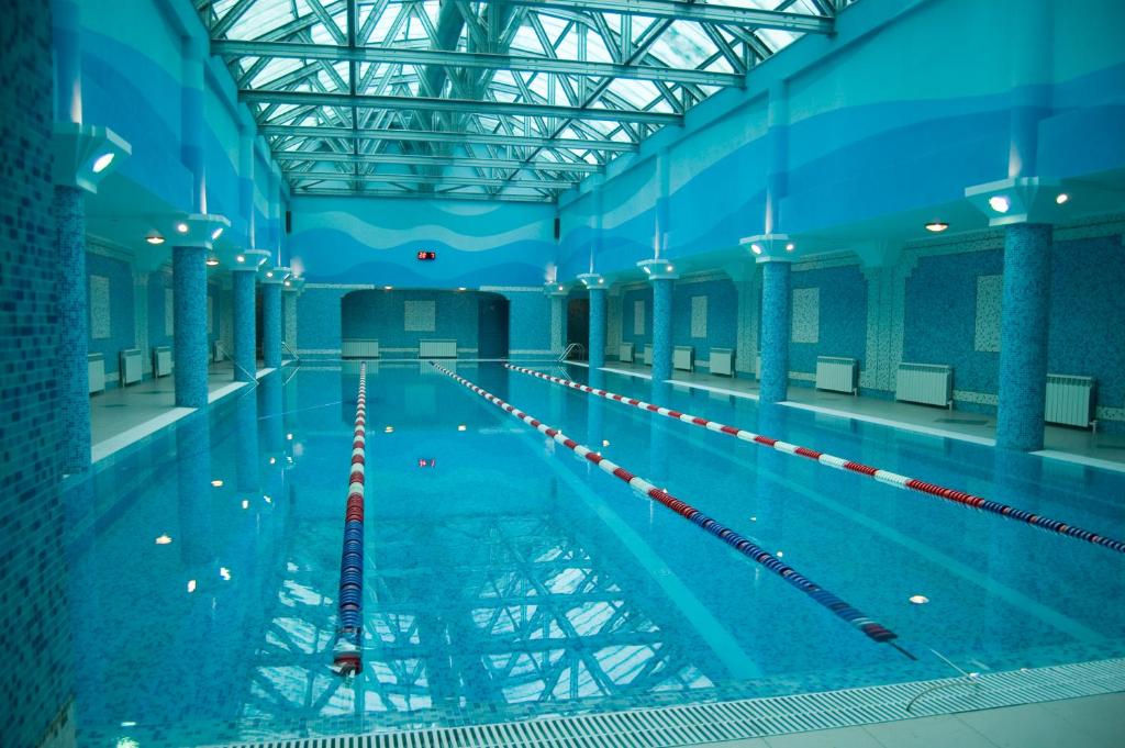 une grande piscine intérieure aux murs bleus dans l'établissement Gulf Stream Hotel, à Kazan
