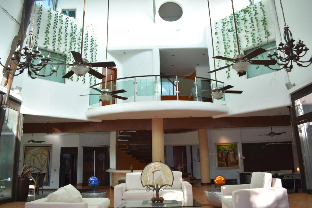 una sala de estar con sofás blancos y una sala redonda en Casa la Selva, en Cancún