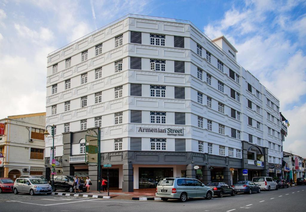 فندق أرمينيان ستريت هيريتيج في جورج تاون: مبنى أبيض على شارع المدينة مع سيارات متوقفة