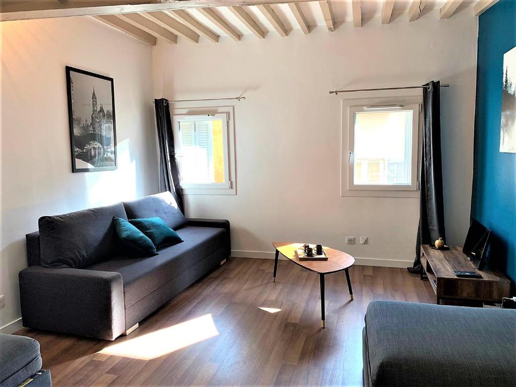 een woonkamer met een bank en een tafel bij LE FOCH in Aix-en-Provence