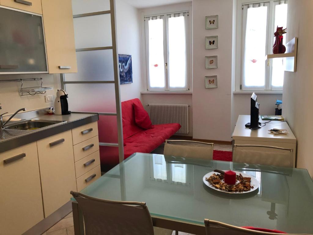 a kitchen with a glass table and a red couch at Calle Corbatto in Grado