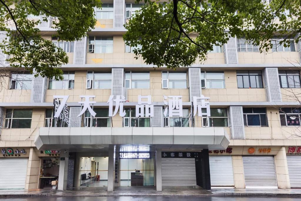 um edifício com cadeiras brancas numa varanda em 7 Days Premium Hotel Hangzhou West Lake Broken Bridge Zhejiang University em Hangzhou