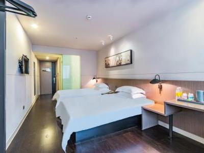 a bedroom with a large white bed and a desk at Jinjiang Inn Select Hangzhou Binjiang University Town Puyan Metro Station in Hangzhou